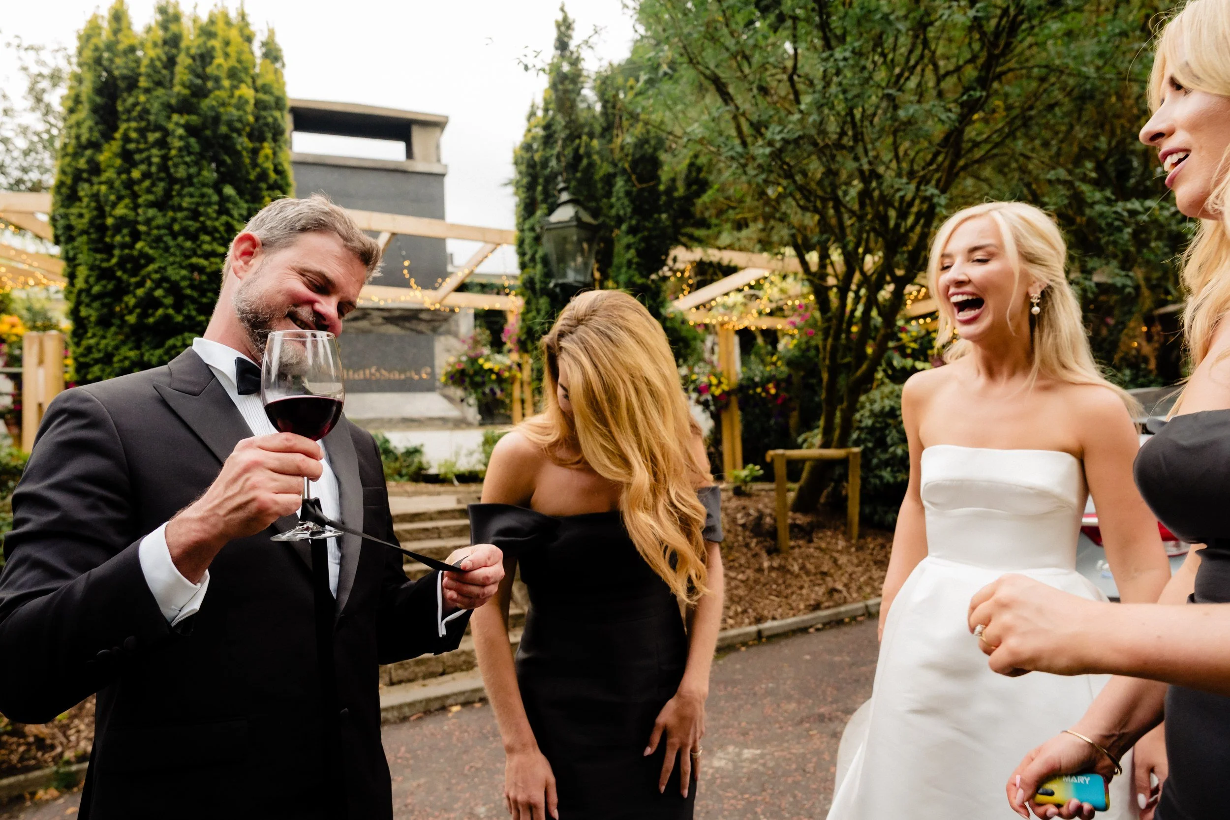galgorm-wedding-photographer-holly-matt-61-guest-laughing-with-wine.jpg