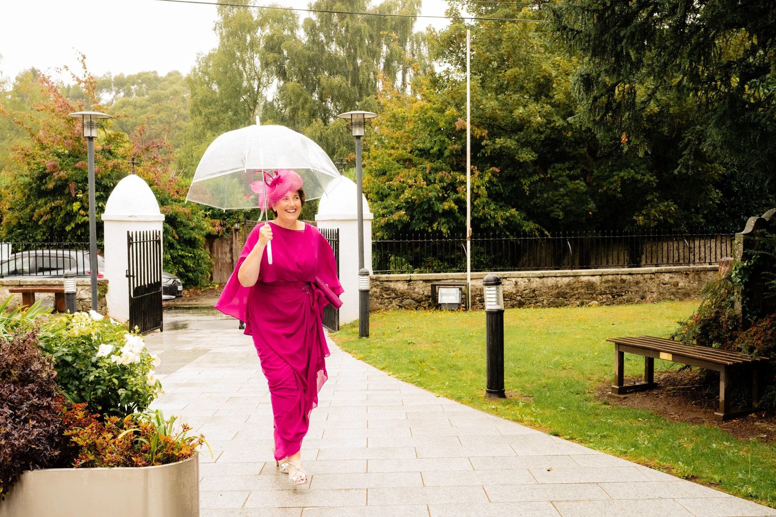 tinakilly-wedding-photographer-laura-james-15-mum-arriving-under-an-umbrella.jpg