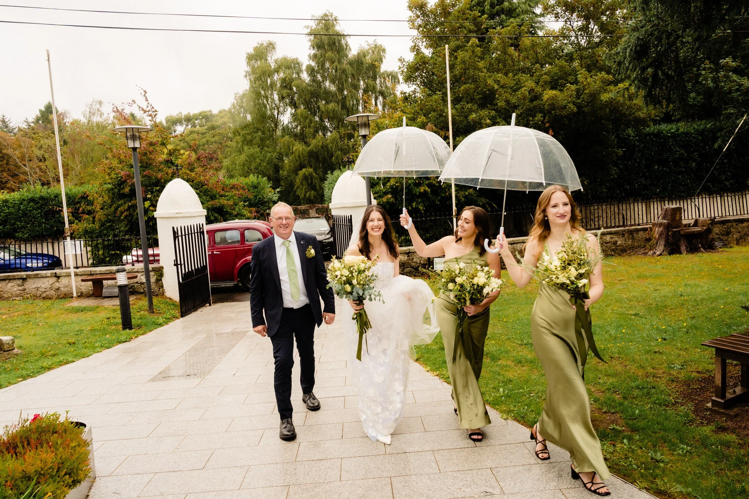 tinakilly-wedding-photographer-laura-james-20-walking-in-under-umbrellas.jpg