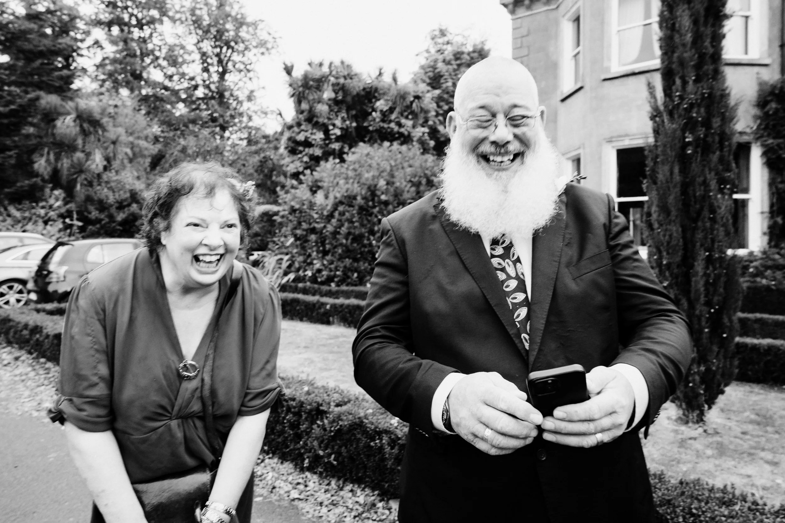 tinakilly-wedding-photographer-laura-james-43-guests-laughing-in-the-garden.jpg