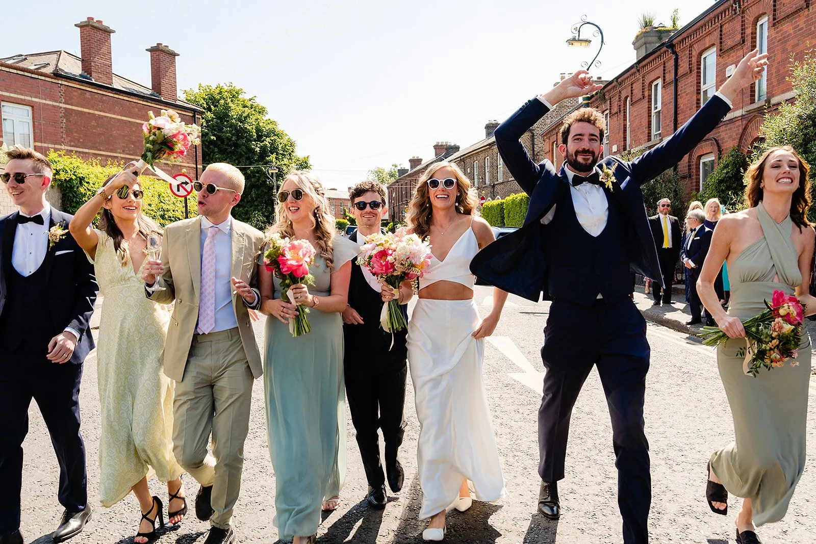 marco-pierre-white-wedding-photographer-elle-iain-55-groom-jumping-in-the-street-with-bridal-party.jpg