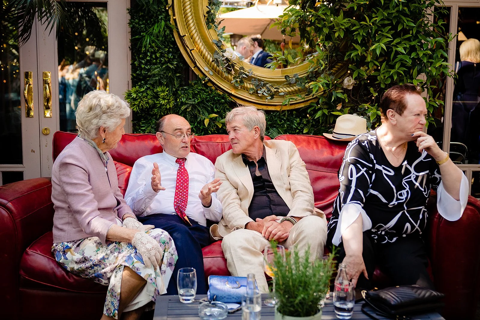 marco-pierre-white-wedding-photographer-elle-iain-62-guests-relaxing-on-the-red-couch.jpg