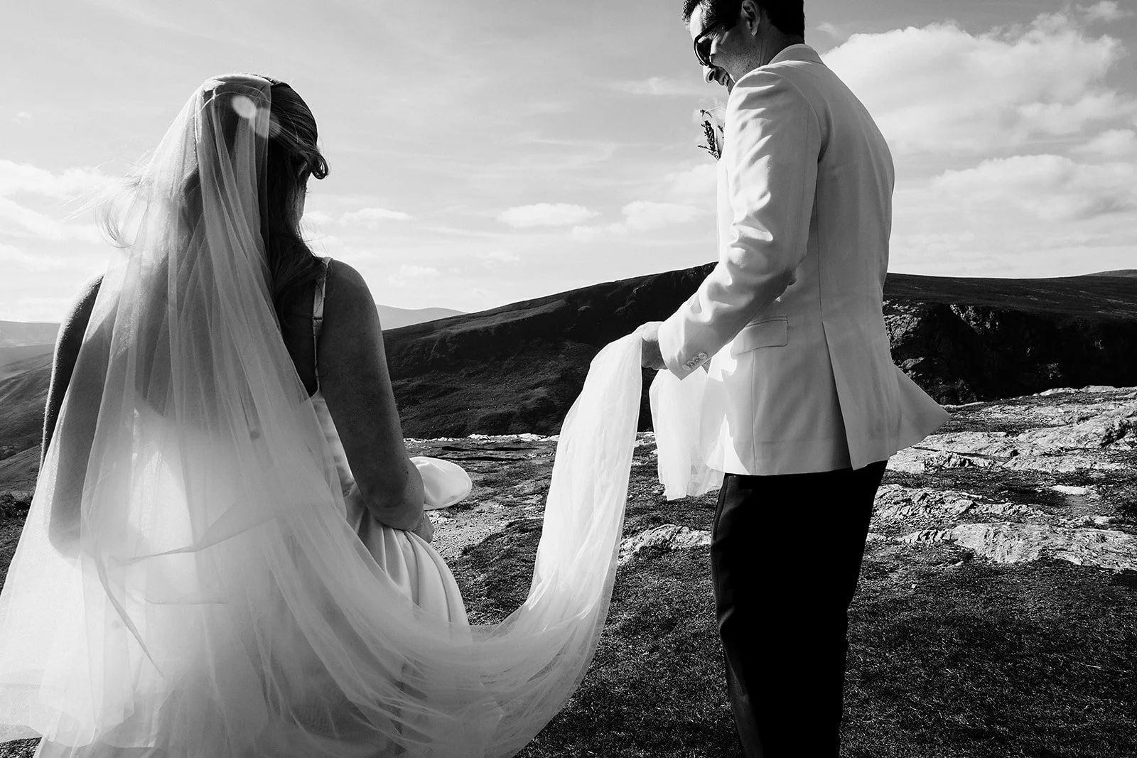black and white photo of married couple walking up lough tay