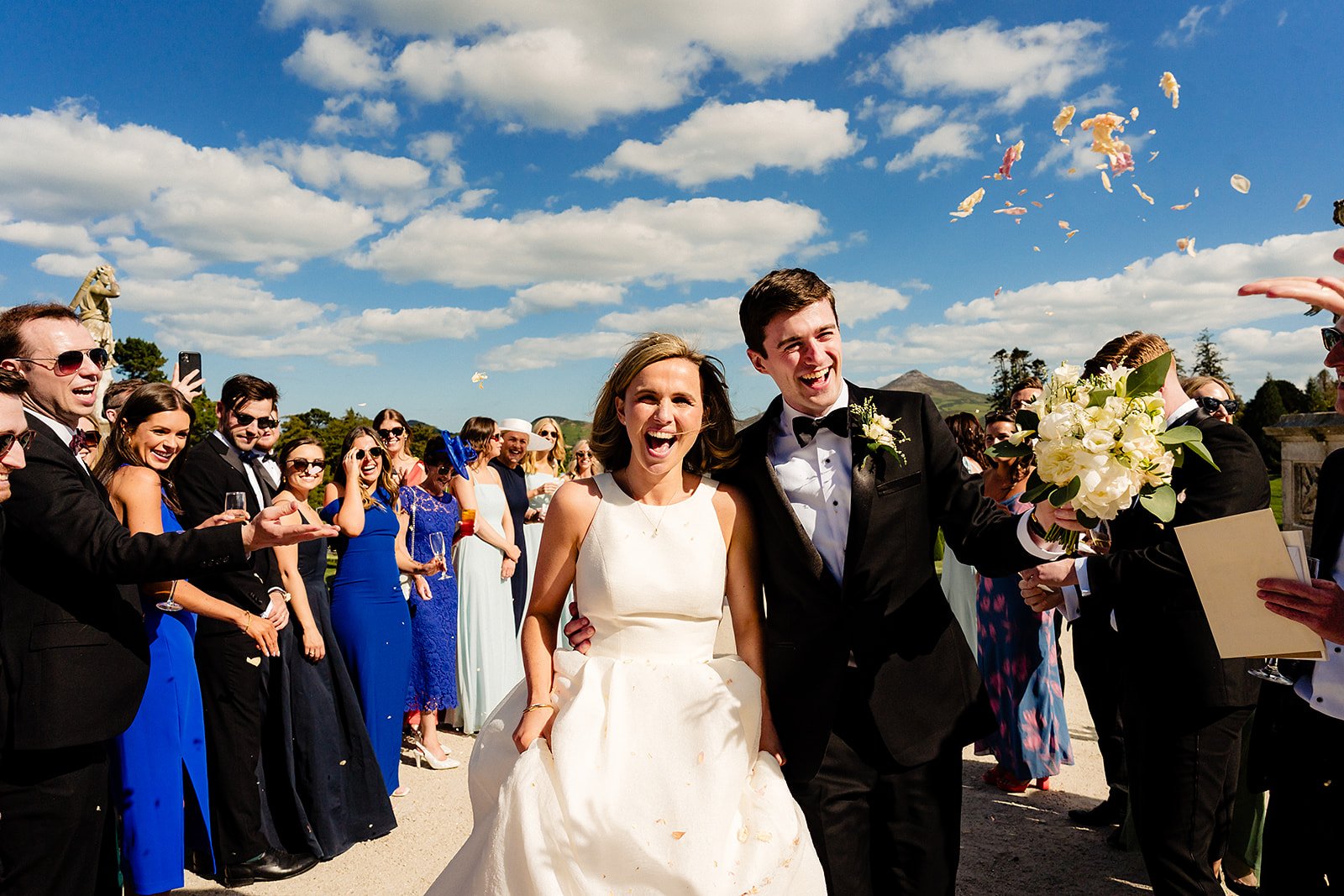 married couple photograph doing confetti run out the back of powerscourt house in wicklow
