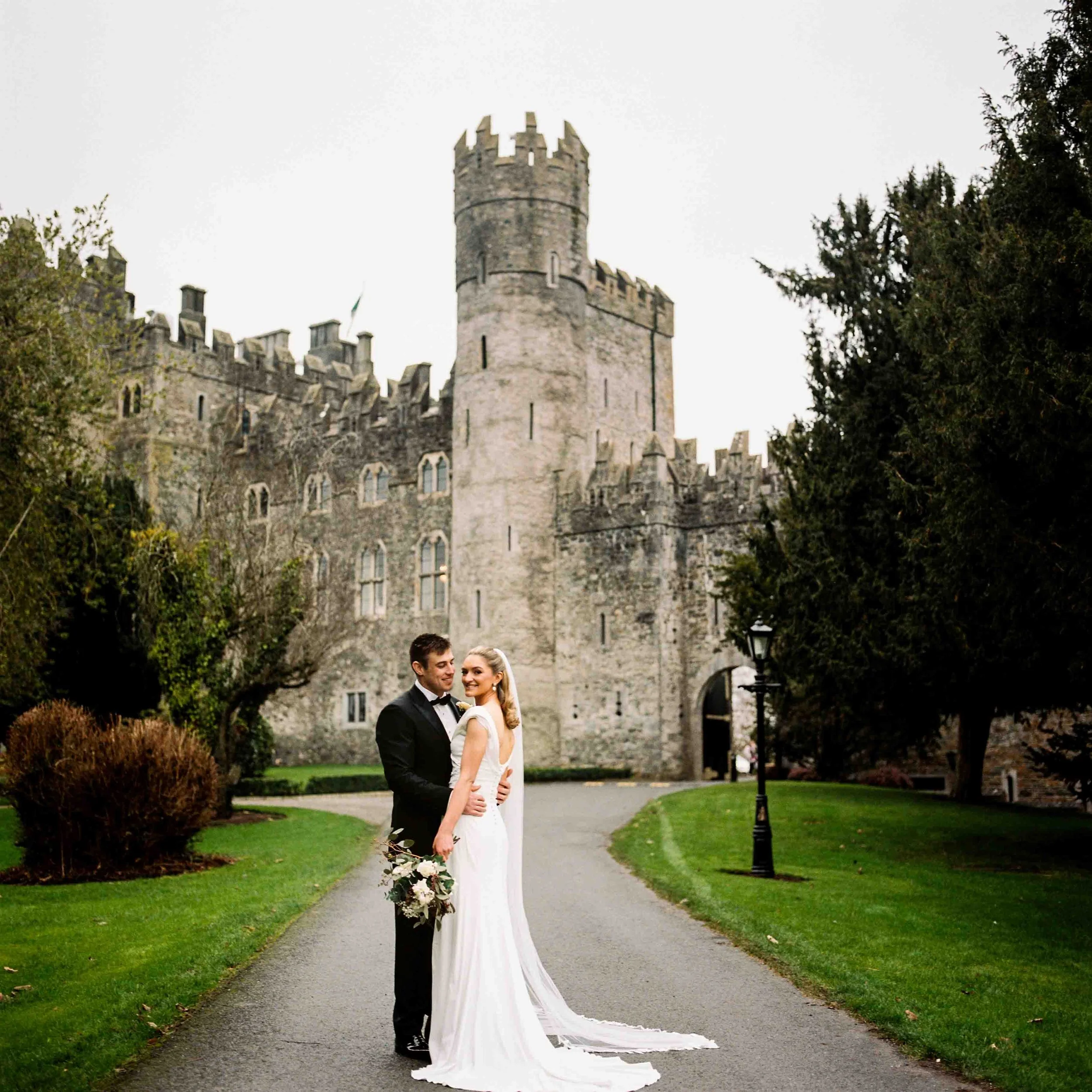 editoiral looking posed wedding couple outside Kilkea caslte film photographer