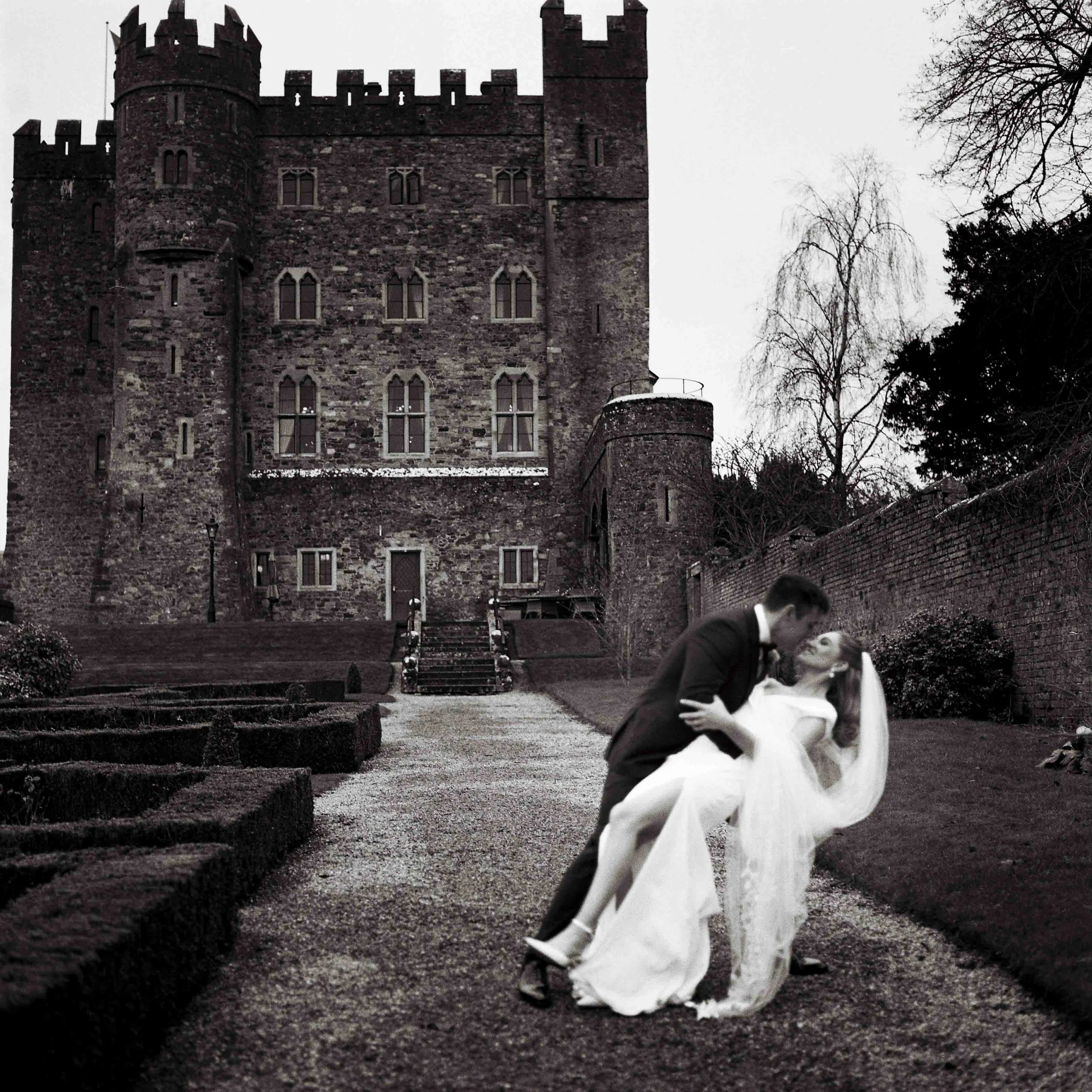 couple doing a dip with kilkea castle in the backgrouund