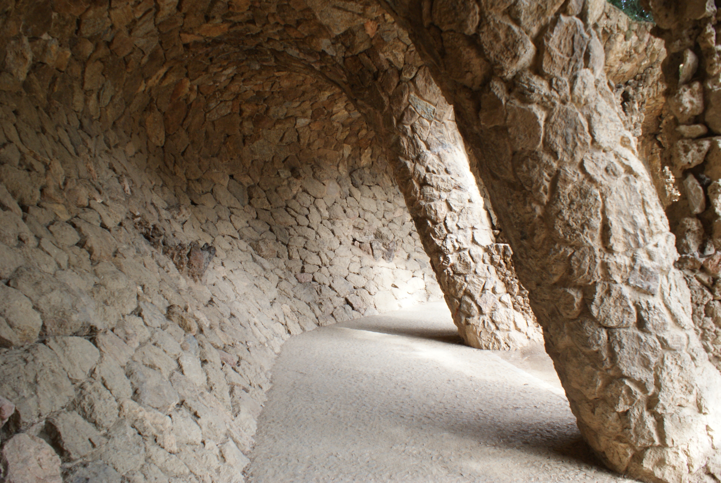 Below the tiles, an archway of rocks lean together in obtuse angles, curving in and out to form a passage way that invites the wanderer further underneath. 