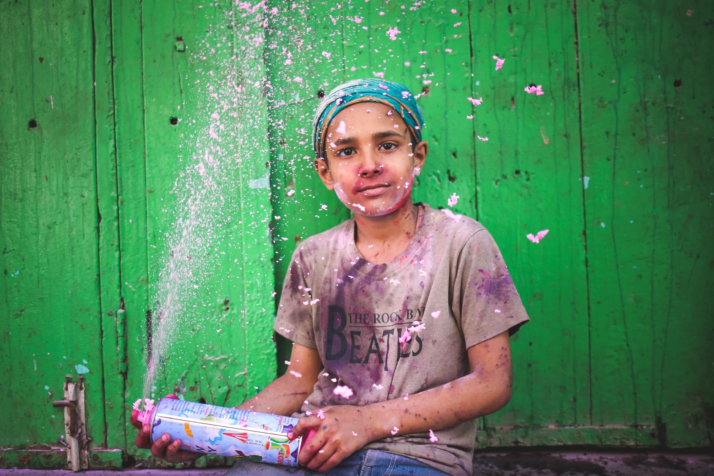 Mathura, India - March 24th, 2016: A boy poses for a portrait in-between gulal throwing. 