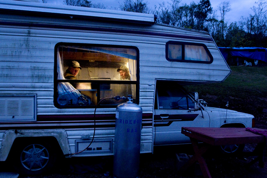 Matt Bowers, left, and Donald Mays look out of the camper that Mays' must live after a September 16 tornado destroyed his trailer. "I won't go camping after this," Mays commented on living in the camper.