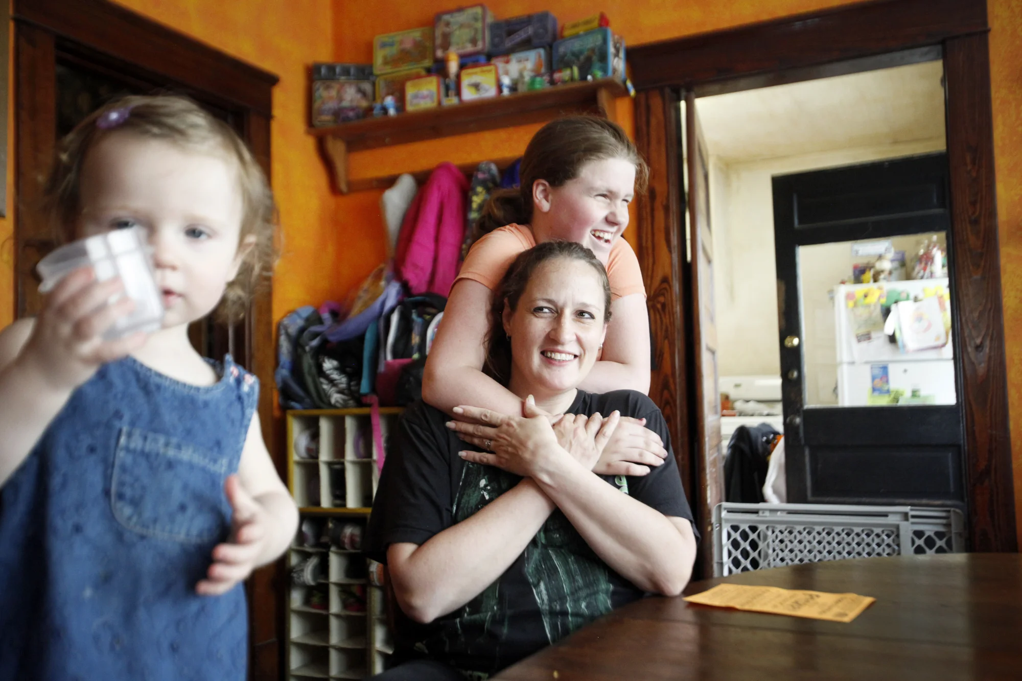  Heather Pletcher smiles as her daughter, Autumn, 11, hugs her Friday. Also pictured is Heather's daughter Annis, 1. Pletcher cares for eight children, four of which are her biological children, two are her half-sisters, one is her stepdaughter and a
