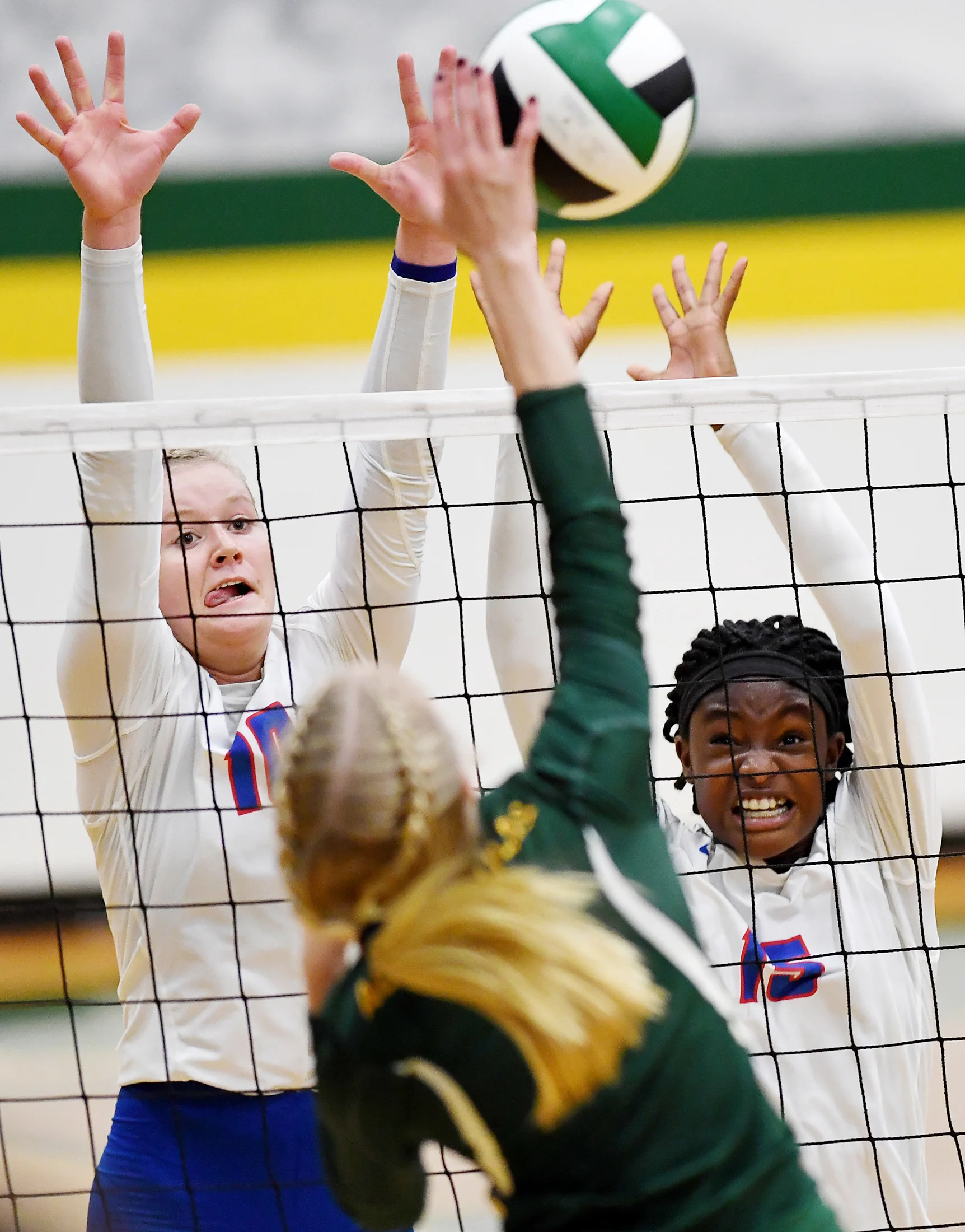  West Henderson's Malia Moore, left, and Daija Jackson attempt to block a spike from Reynolds' Abby Hutzler in the conference championship Oct. 4, 2018 in Asheville. 