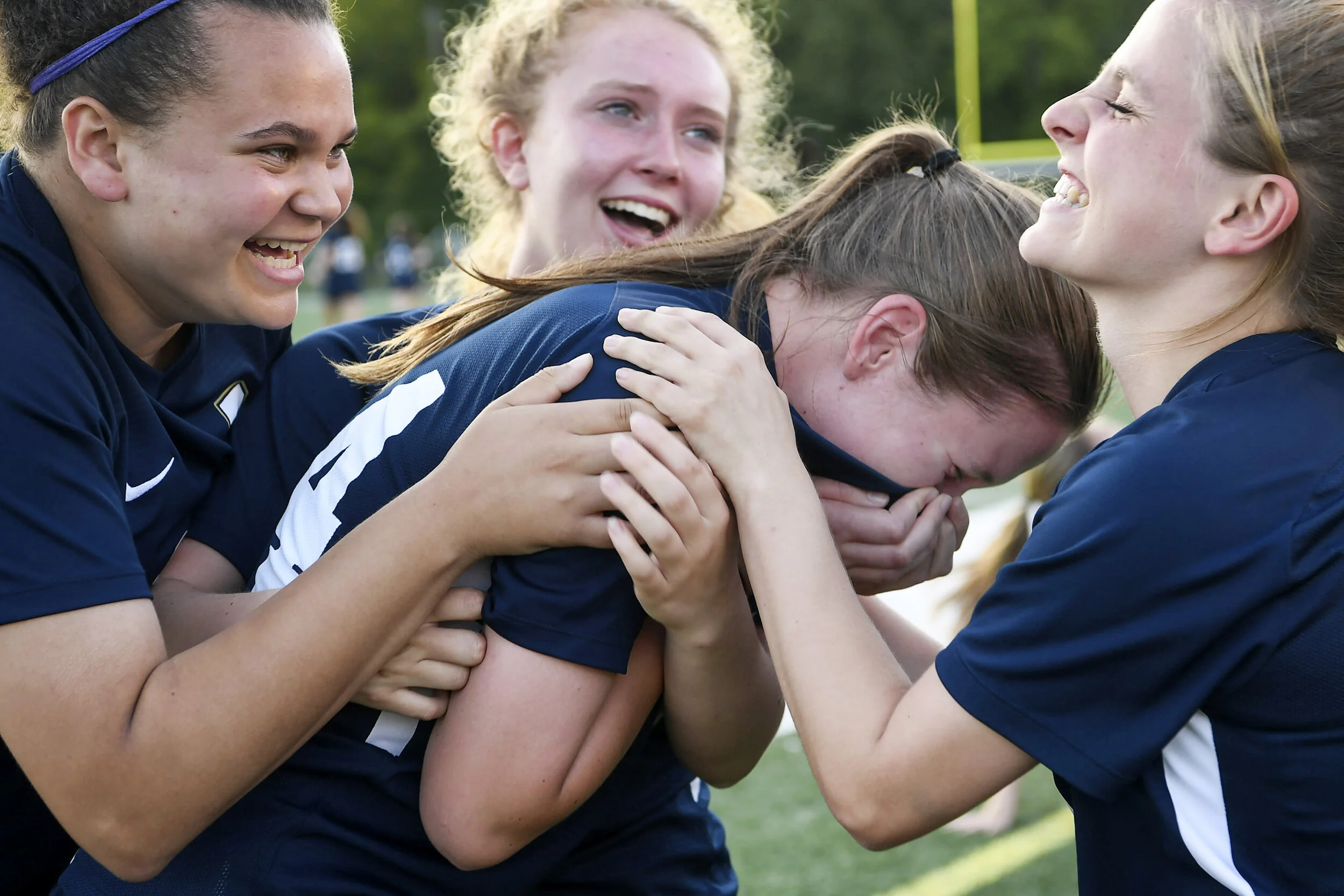  From left, Roberson's Ashley McGraw, Lucy Manner and Riley Williamson laugh as they hug Devin Simmons while she cries after the Rams tied Northern Guilford in the final minutes of the WNC regional final May 21, 2019. Roberson went on to defeat North
