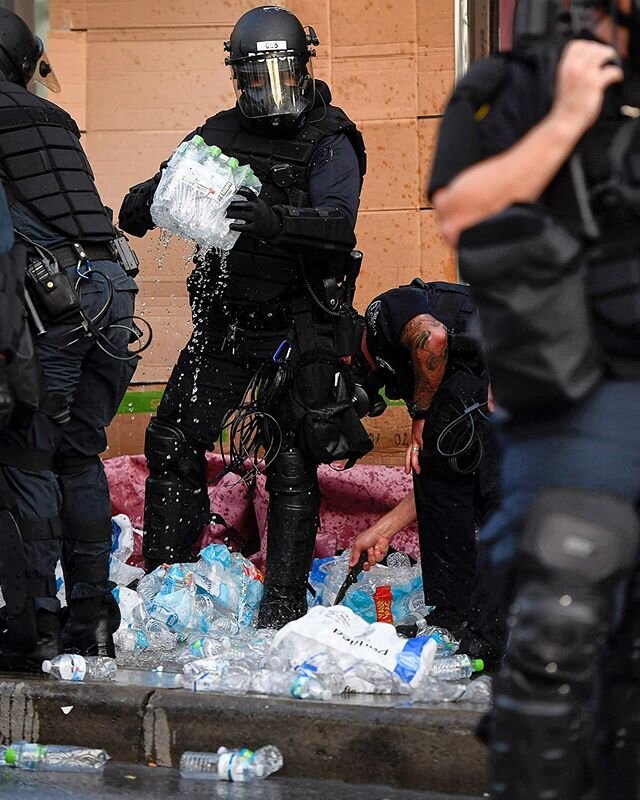 Asheville Police surround a medic station created by protesters as they stab water bottles with knives and tip over tables of medical supplies and food June 2, 2020. The medic team, made of EMTs and doctors, said the medical station was approved by t