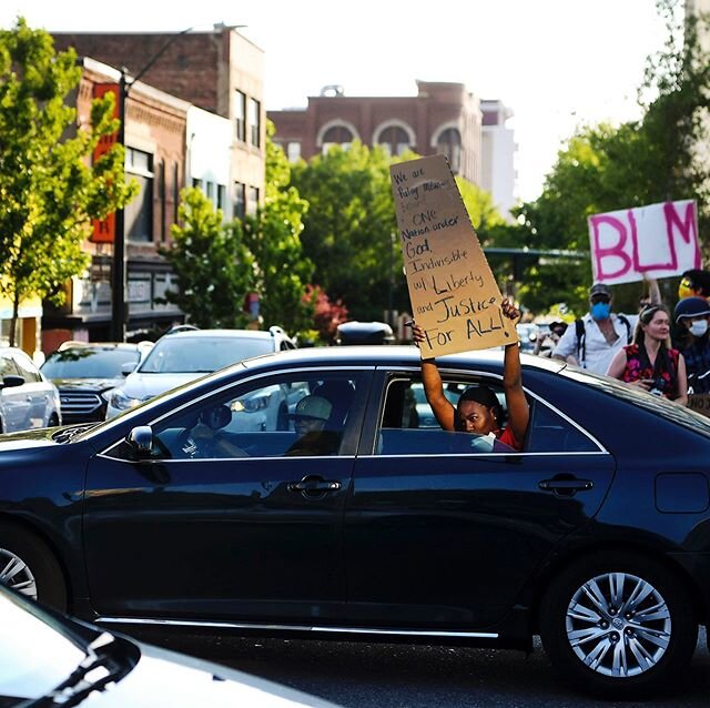A woman holds a sign reading &ldquo;We are putting meaning behind &lsquo;One nation under God, indivisible with liberty and justice for all!&rsquo;&rdquo; as a car is driven past protesters in Asheville June 2, 2020. 📷 @angwilhelm .
.
.
.
.
#ashevil