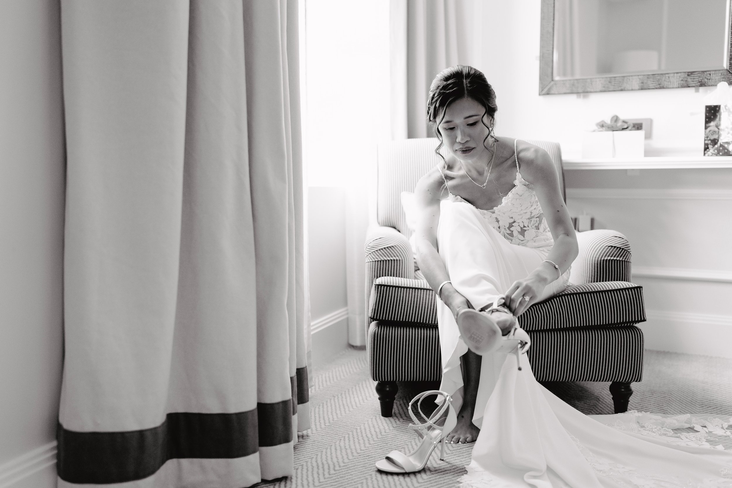 bride putting on shoes at langham hotel
