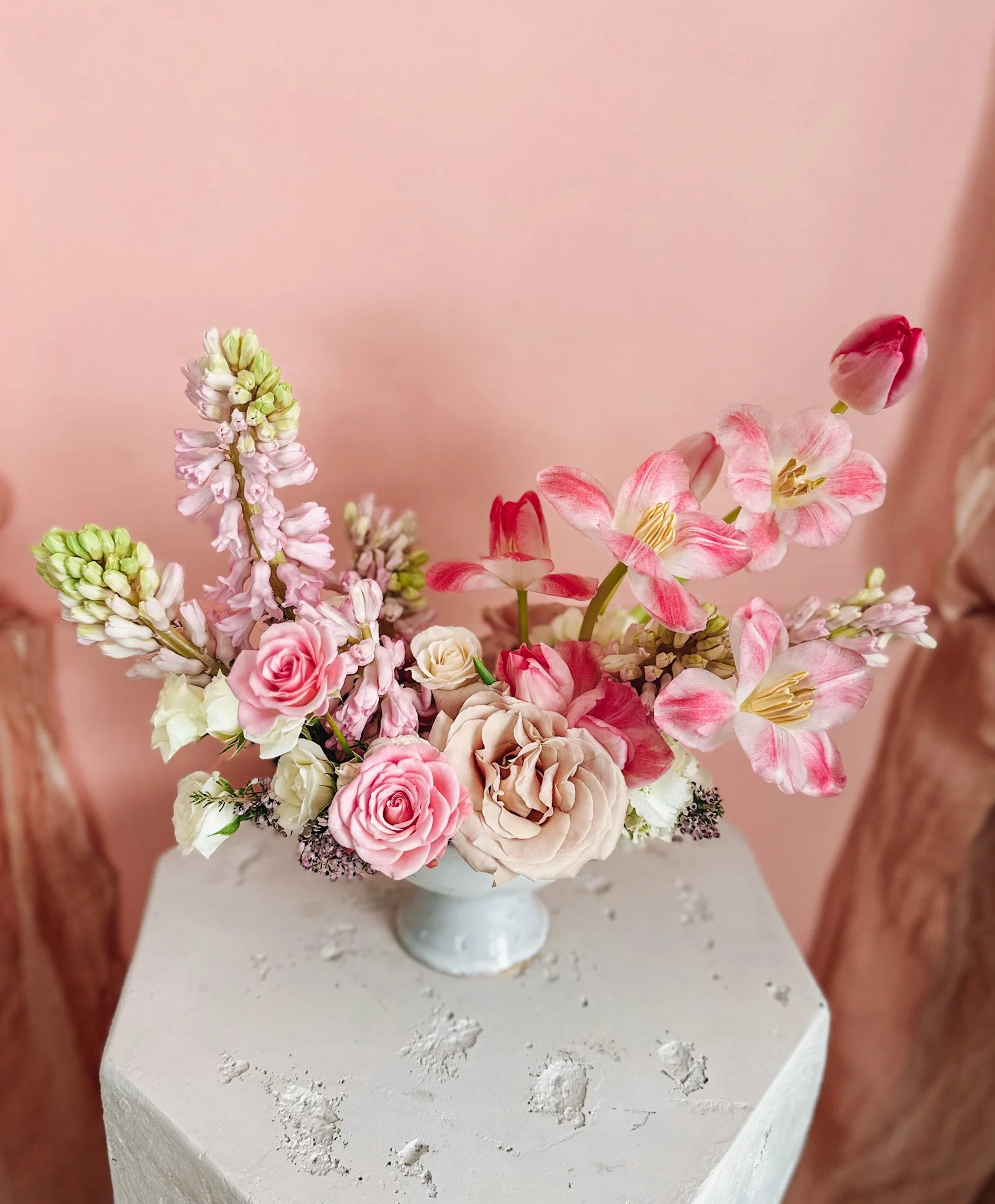 Pastel Valentine’s Day floral arrangement with blush roses, soft pink blooms, and creamy florals arranged in a pale pedestal bowl, available for Edmonton St Albert and Sturgeon County flower delivery.