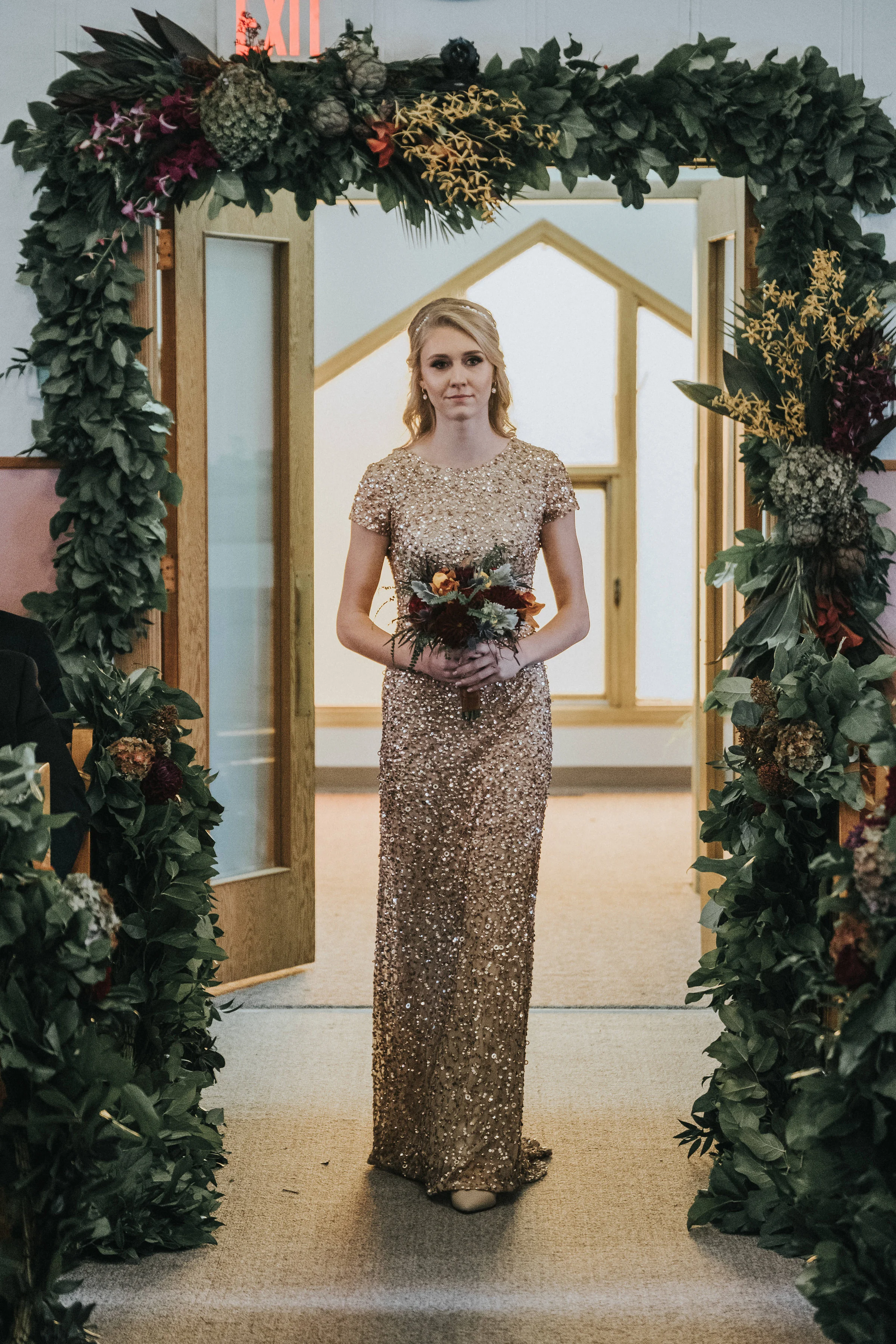 Sparkling Bride Under Lush Floral Arch