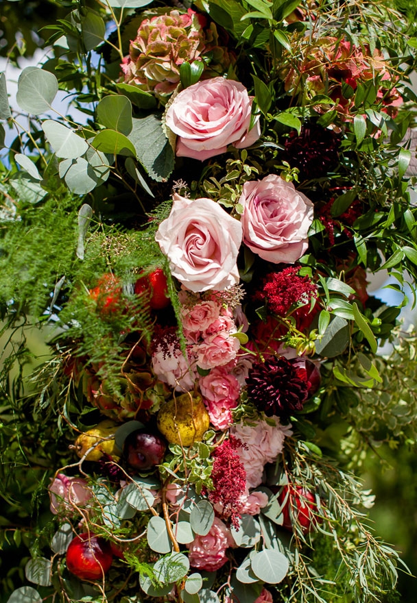 A Wedding Ceremony Arch Full of Fruit and Flowers