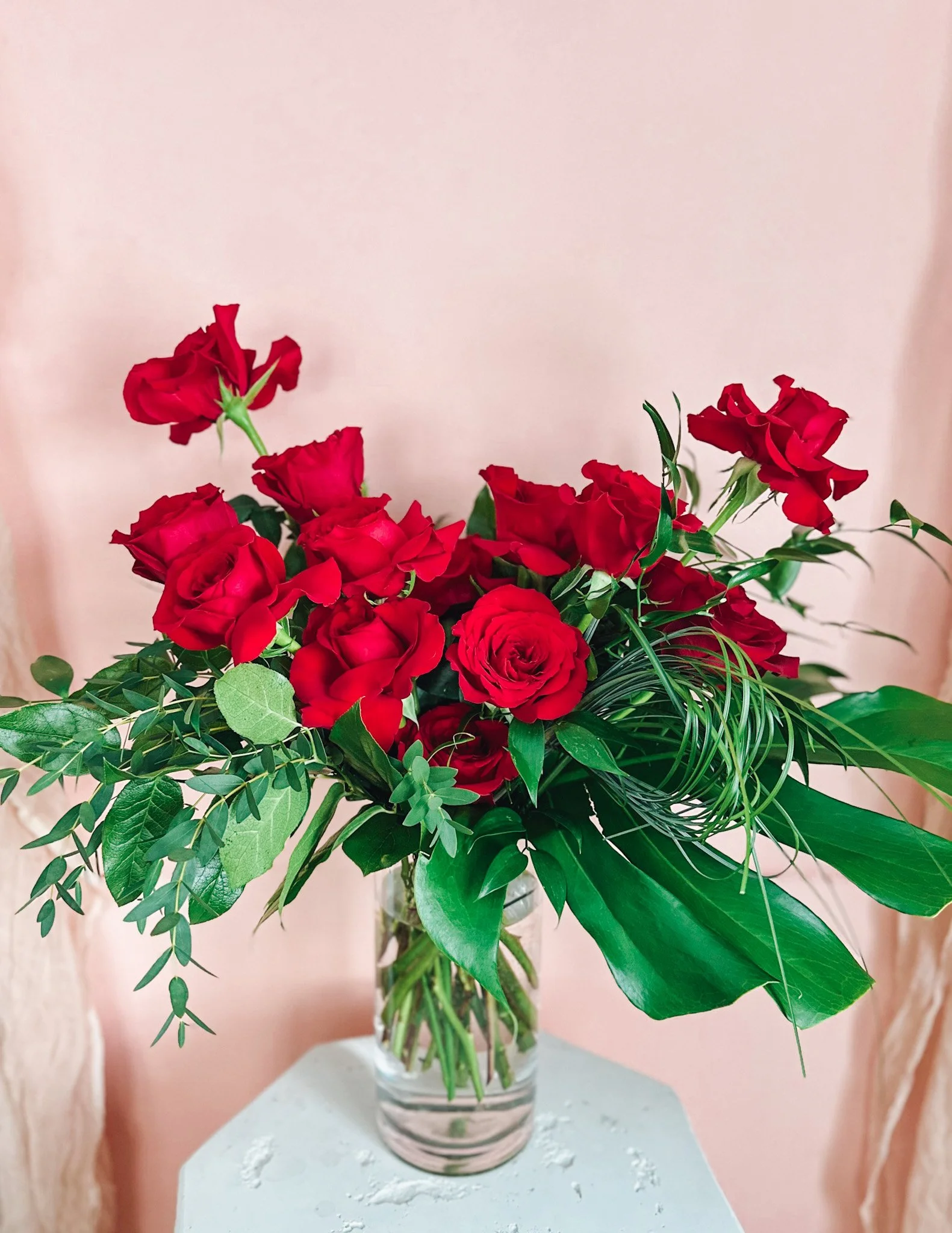 Luxury red rose Valentine’s Day arrangement in a clear glass vase, available for delivery in Edmonton St Albert and Sturgeon County.