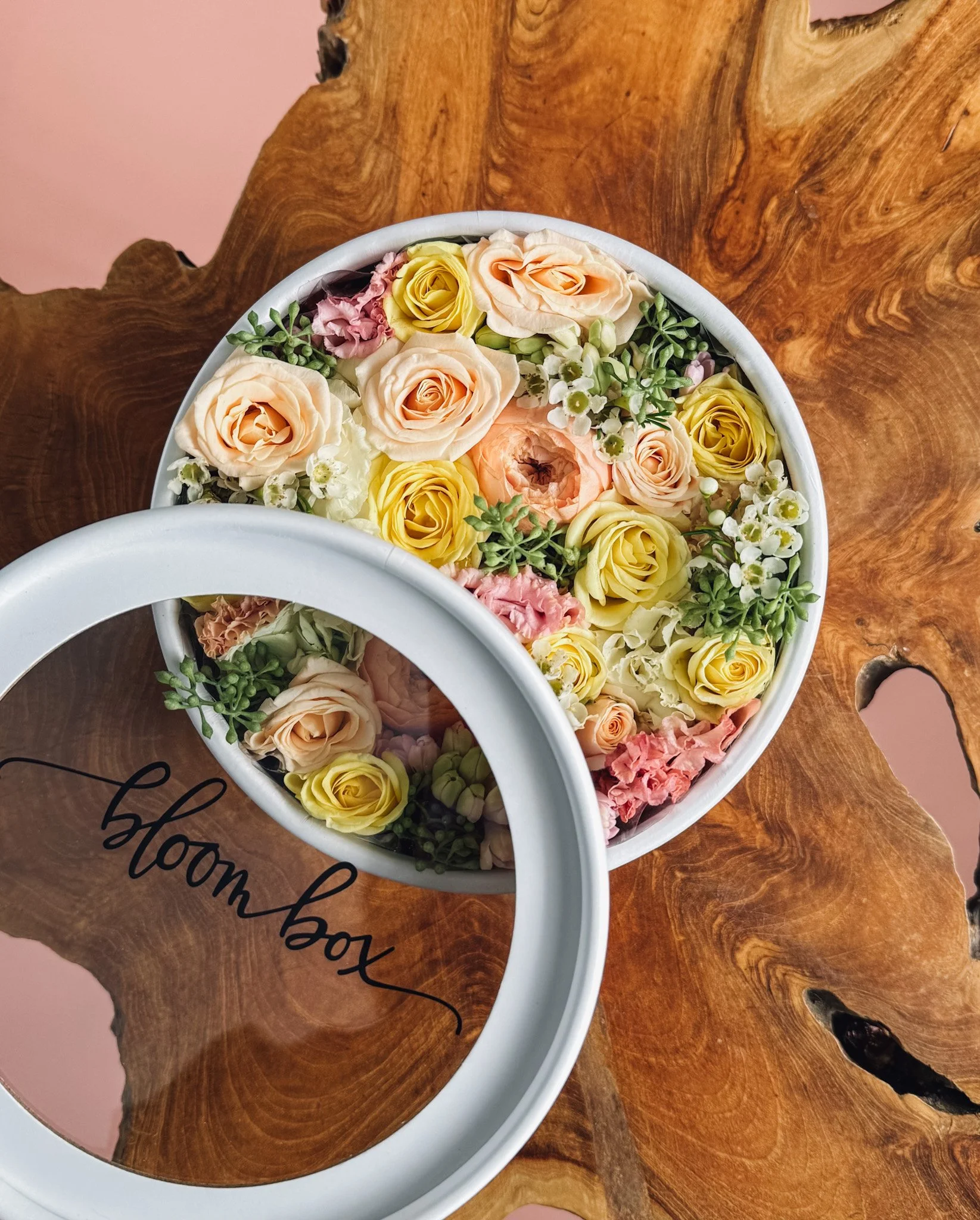 Pastel blush preserved flower box with roses and delicate filler florals displayed on wood surface, Edmonton flower delivery