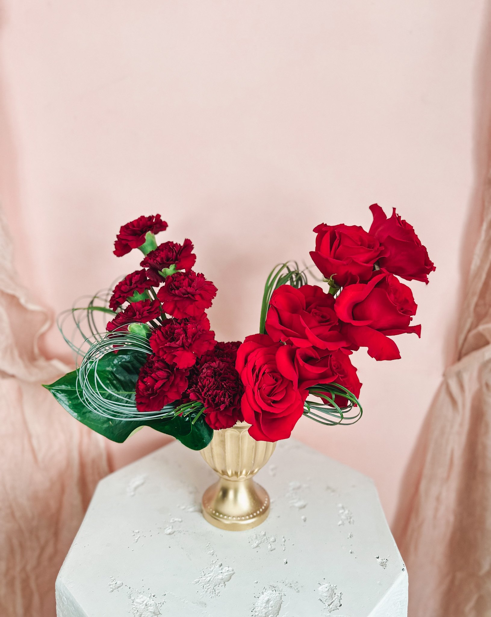The Lover’s Stack featuring lush red roses and deep red carnations styled in a modern gold vase, handcrafted by an Edmonton and St. Albert florist