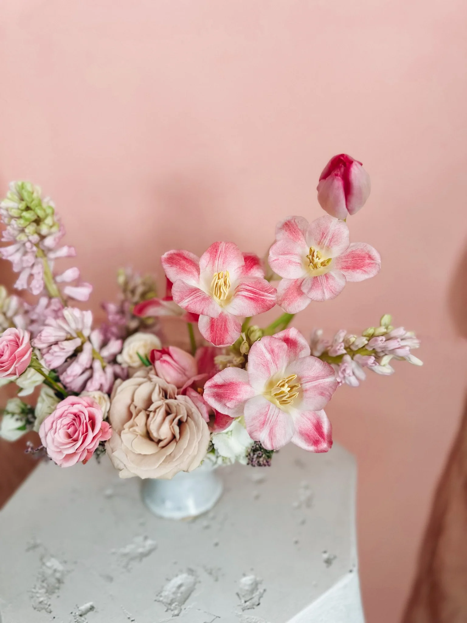 Pastel Valentine’s Day floral arrangement with blush roses, soft pink blooms, and creamy florals arranged in a pale pedestal bowl, available for Edmonton St Albert and Sturgeon County flower delivery.