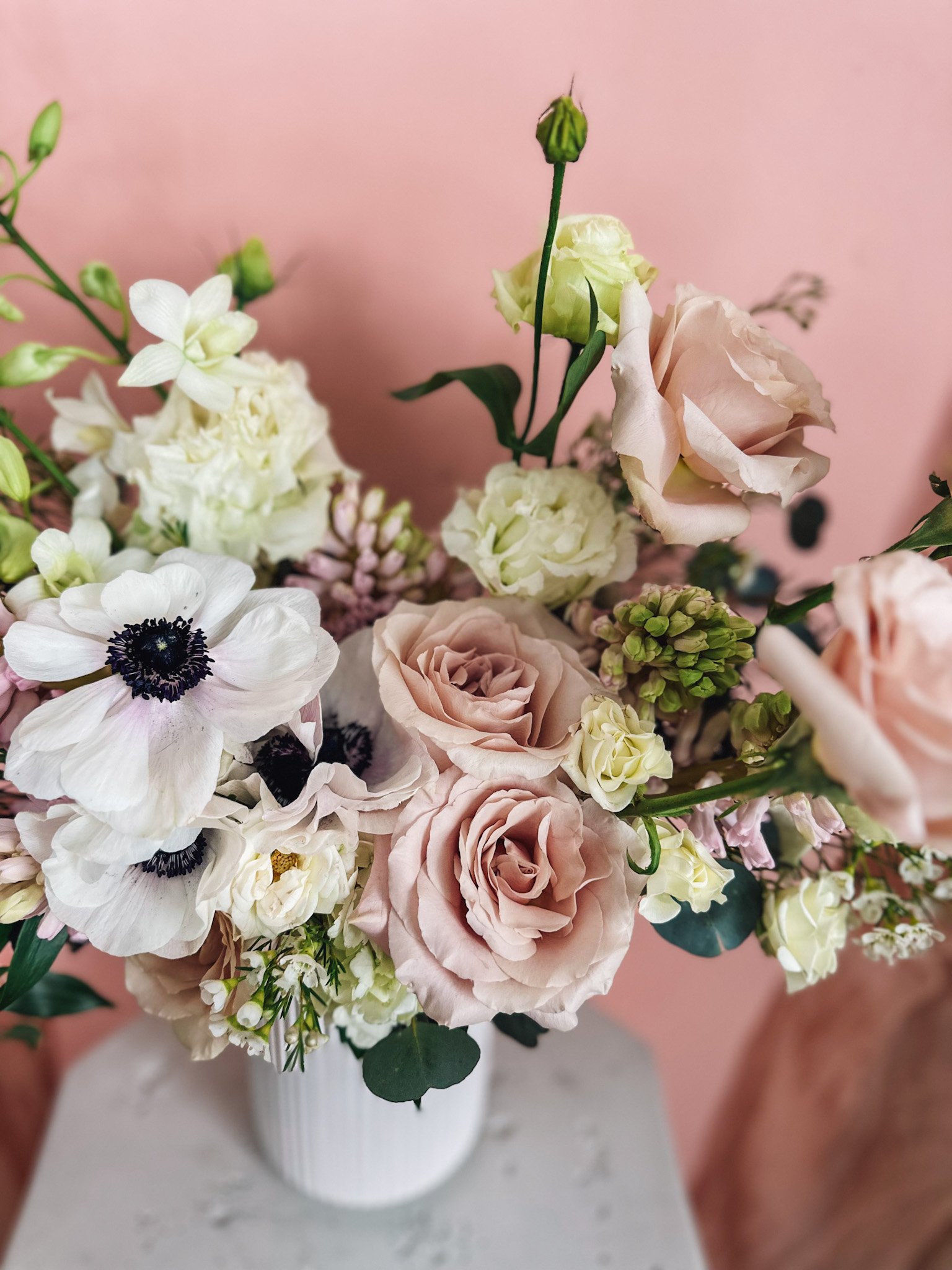 Pastel Perfection flower arrangement featuring blush roses, white anemones and soft spring blooms in a modern white vase, available for delivery in Edmonton and St. Albert