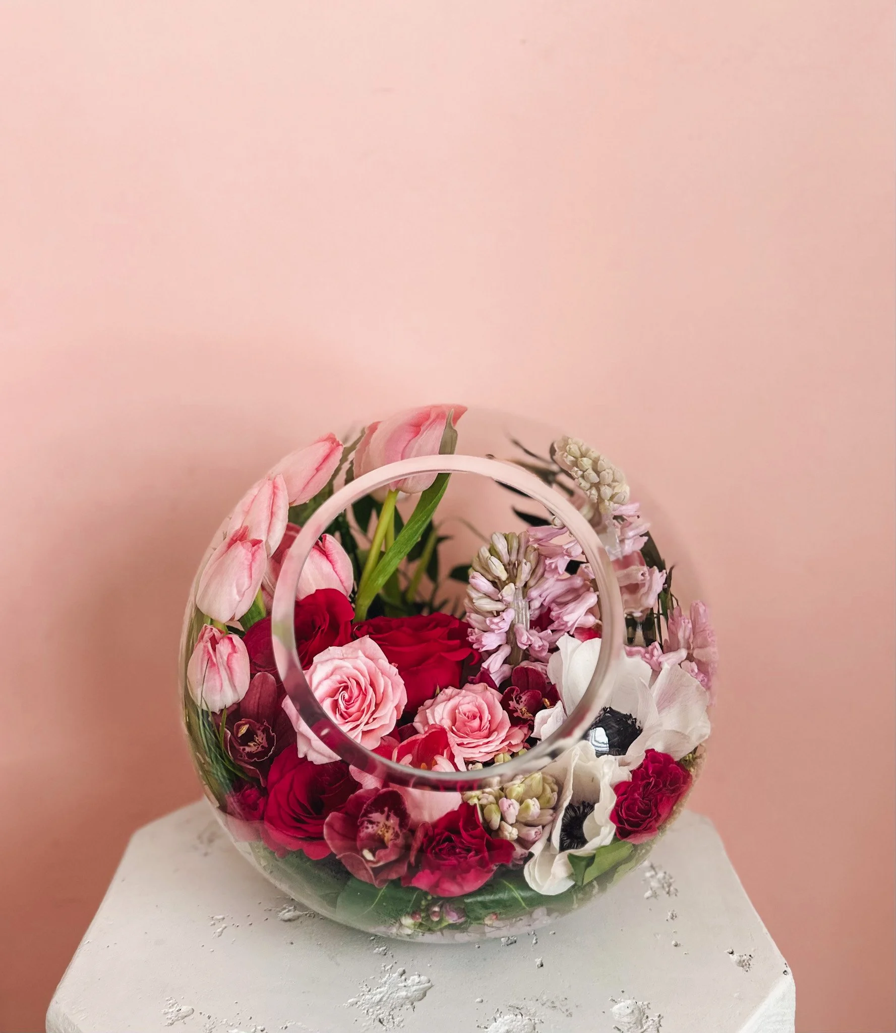 Pink and red rose floral arrangement in a modern glass bowl with orchids and spring blooms for Valentine’s Day, available for delivery in Edmonton, St. Albert and surrounding areas.