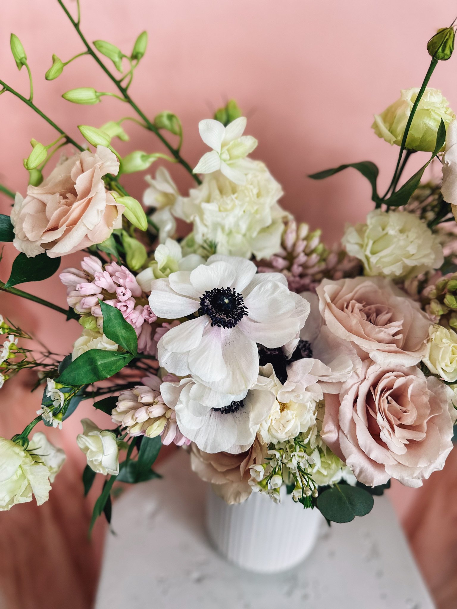 Pastel Perfection bouquet with blush roses, white anemones and pastel florals in a white vase for delivery in Edmonton and St. Albert