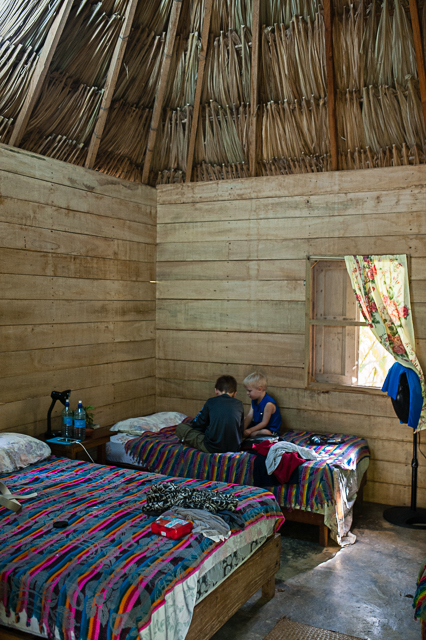The boys relax inside our hut, which had cool concrete floors, thatched roof, fans, and an attached bathroom/shower with hot water.