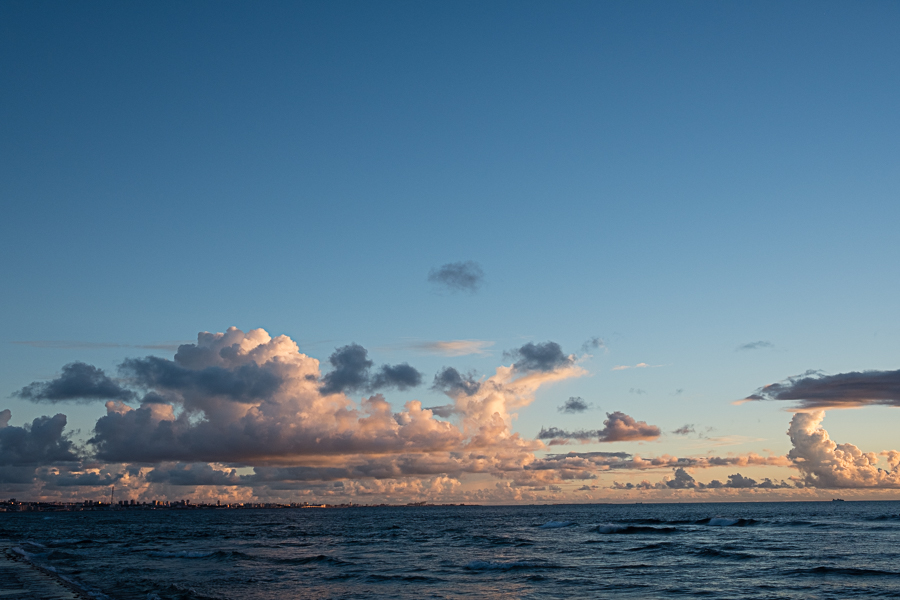 Colors spread to the fluffy clouds over Naha to the south.