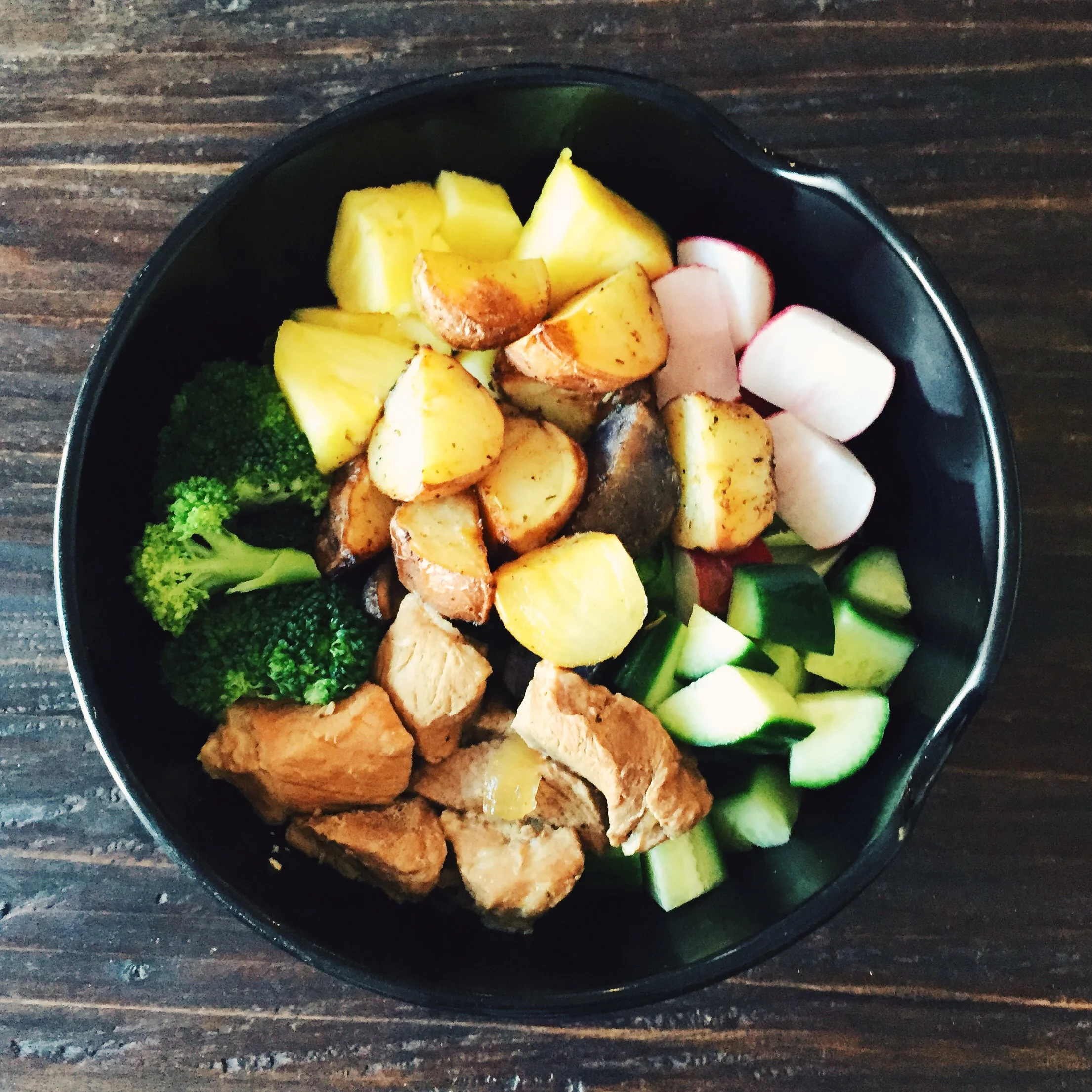 Leftover salad bowl. Steamed broccoli, diced cucumber, radish, pineapple, roasted potatoes, and pork adobo over romaine lettuce.
