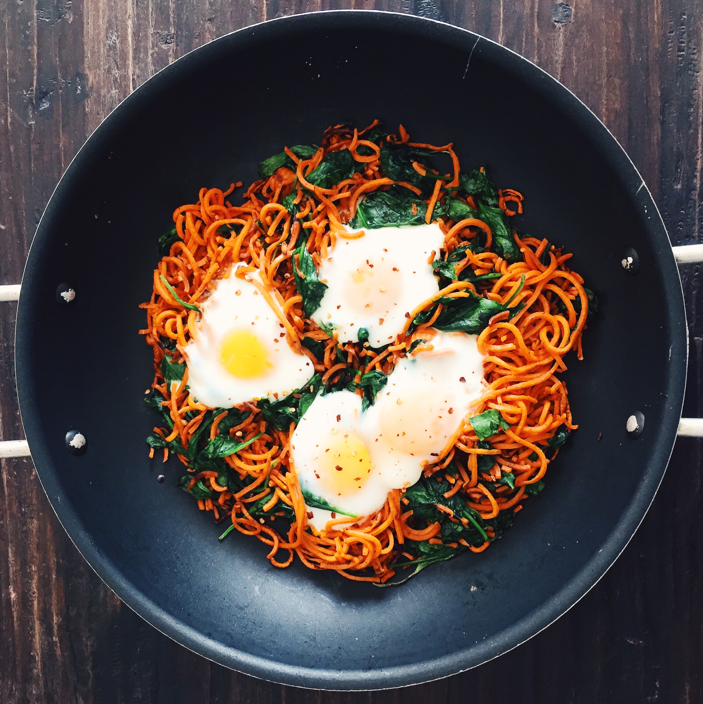 Sweet potatoes spirals with spinach and baked eggs. Cook the potatoes first with olive oil, sea salt, black pepper, and garlic powder for about 10 minutes then add the spinach. Crack eggs on top then cover it with foil for 5-7 minutes depending on how well done you like your eggs. Sprinkle red chili flakes and serve.
