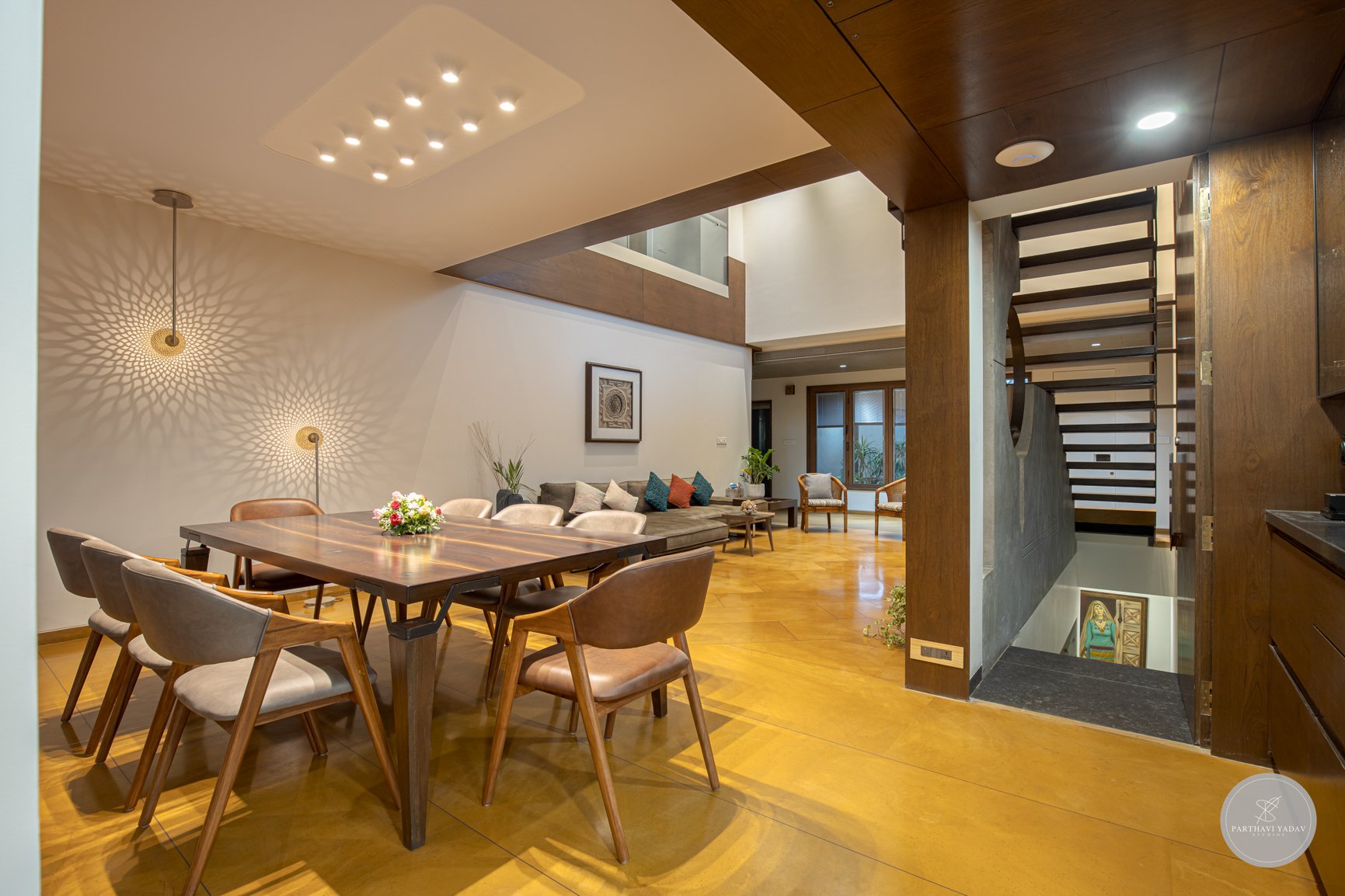 best interior photographer in pune bangalore - custom wooden dining table with award winning lamps and ceiling lights with stairs joining the living room.jpg
