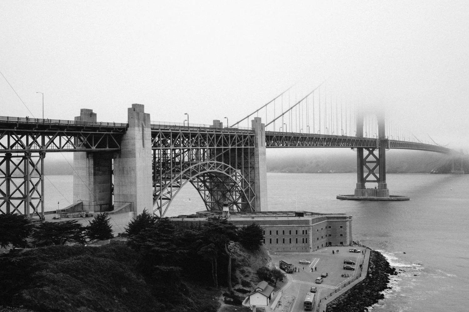 A monochrome view of the Golden Gate partially covered by the already characteristic fog