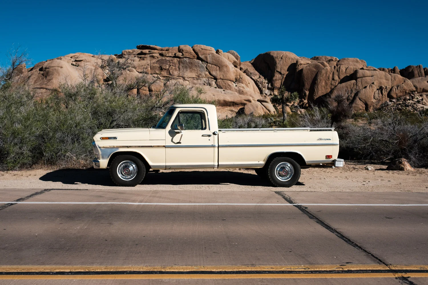 A classic pick-up truck parked alongside Park Boulevard Rd . 