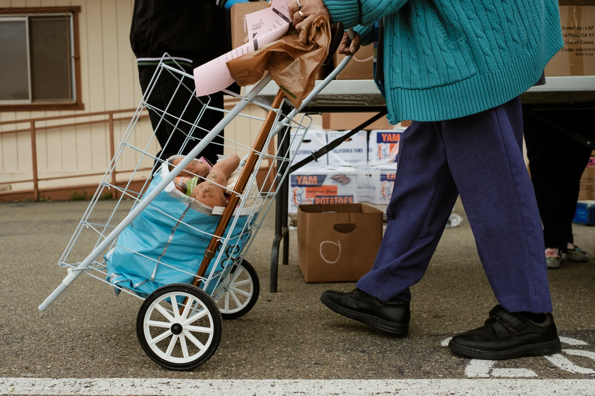 An elderly woman receiving food during a donation program organized by Feeding San Diego
