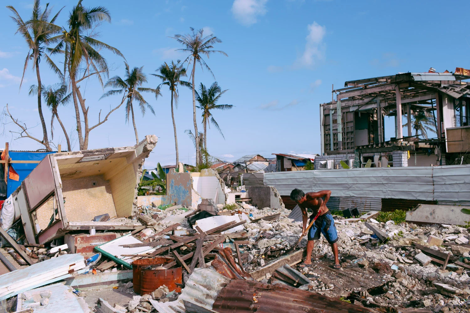 A man collects debris of what was left of his house after typhoon Haiyan (Yolanda) in Tacloban, Philippines.