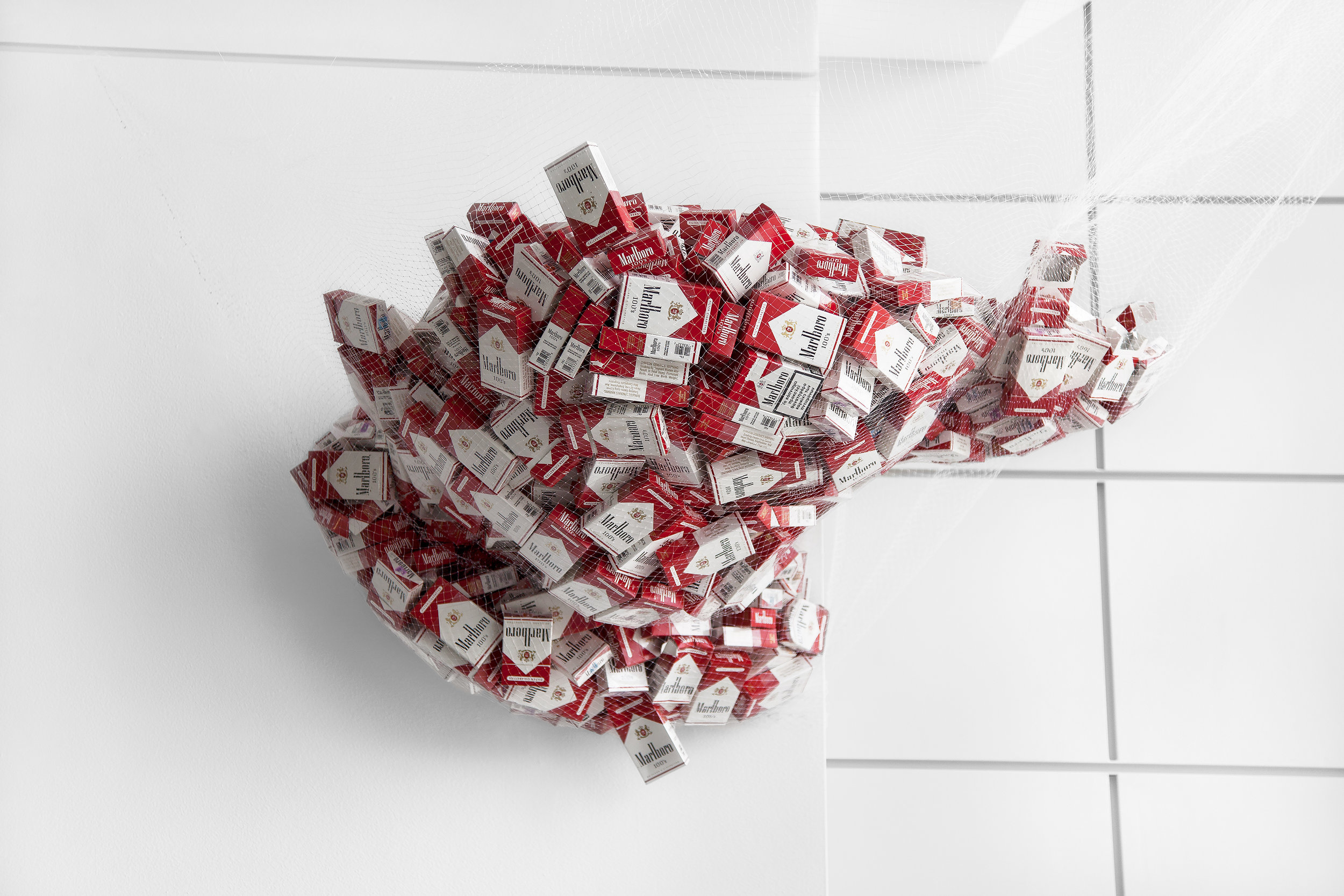 Pax (ongoing), 2012-2014, approx. 730 consumed/ empty packs of Marlboro Reds 100's, minnow fishing net