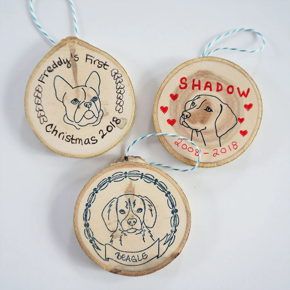 Whether you’re celebrating your pup’s first Christmas or have recently said goodbye to your best bud, making your own dog ornament is simple: here I used a tree slice (sanded), some StazOn ink (if you order a black or navy blue ink pad from us, you’ll receive that brand), a piece of baker’s twine adhered with hot glue, some regular ballpoint pens, and of course our dog portrait stamps .