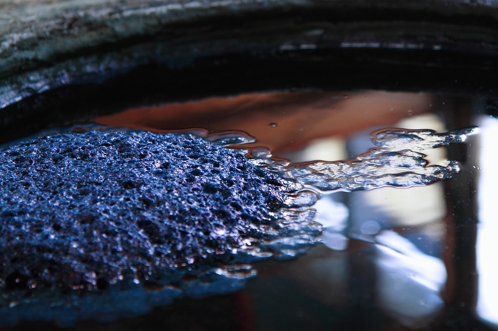 A vat of indigo dye. Indigo is among the oldest dyes to be used for textile dyeing and printing. 
