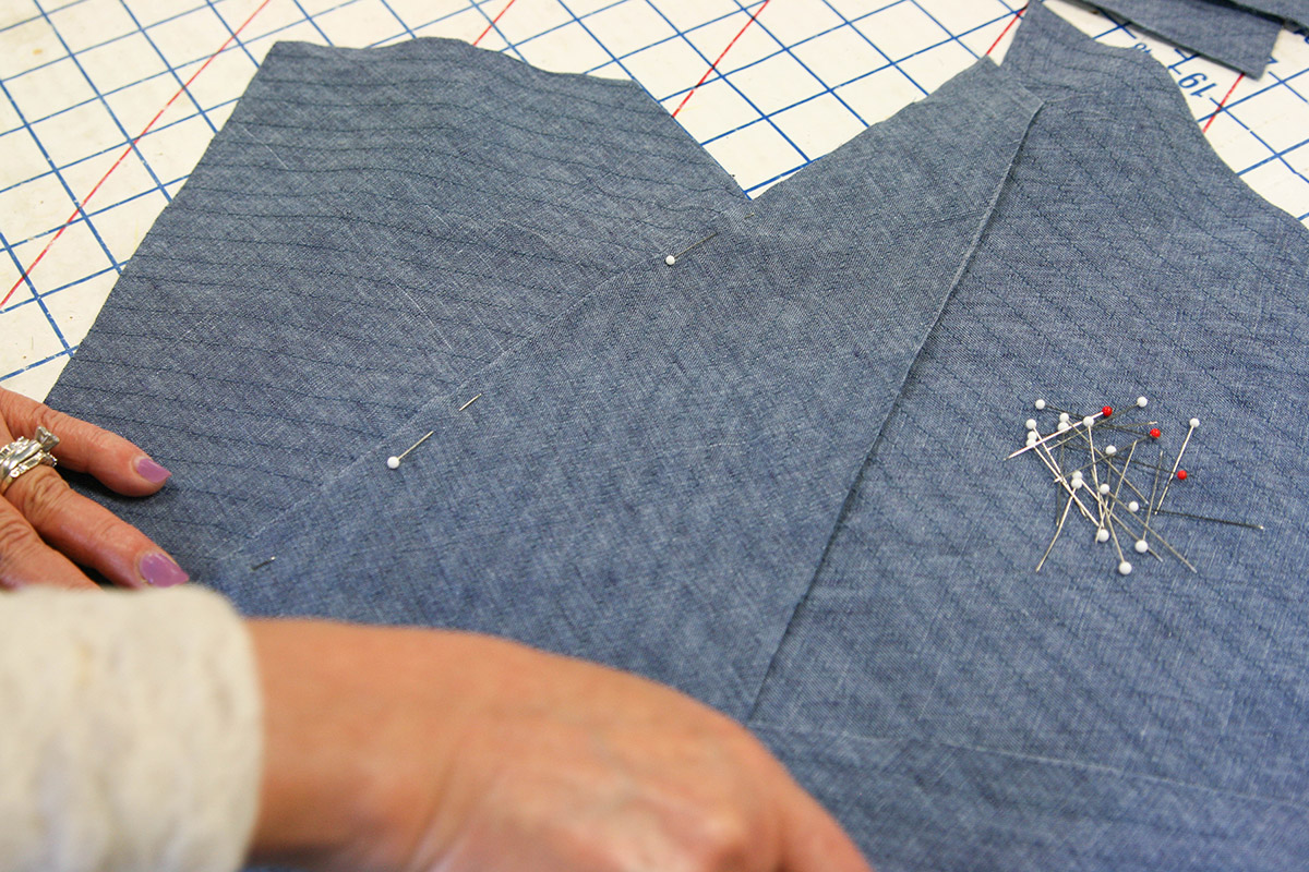 Pinning each overlapping section together in order to stitch together.