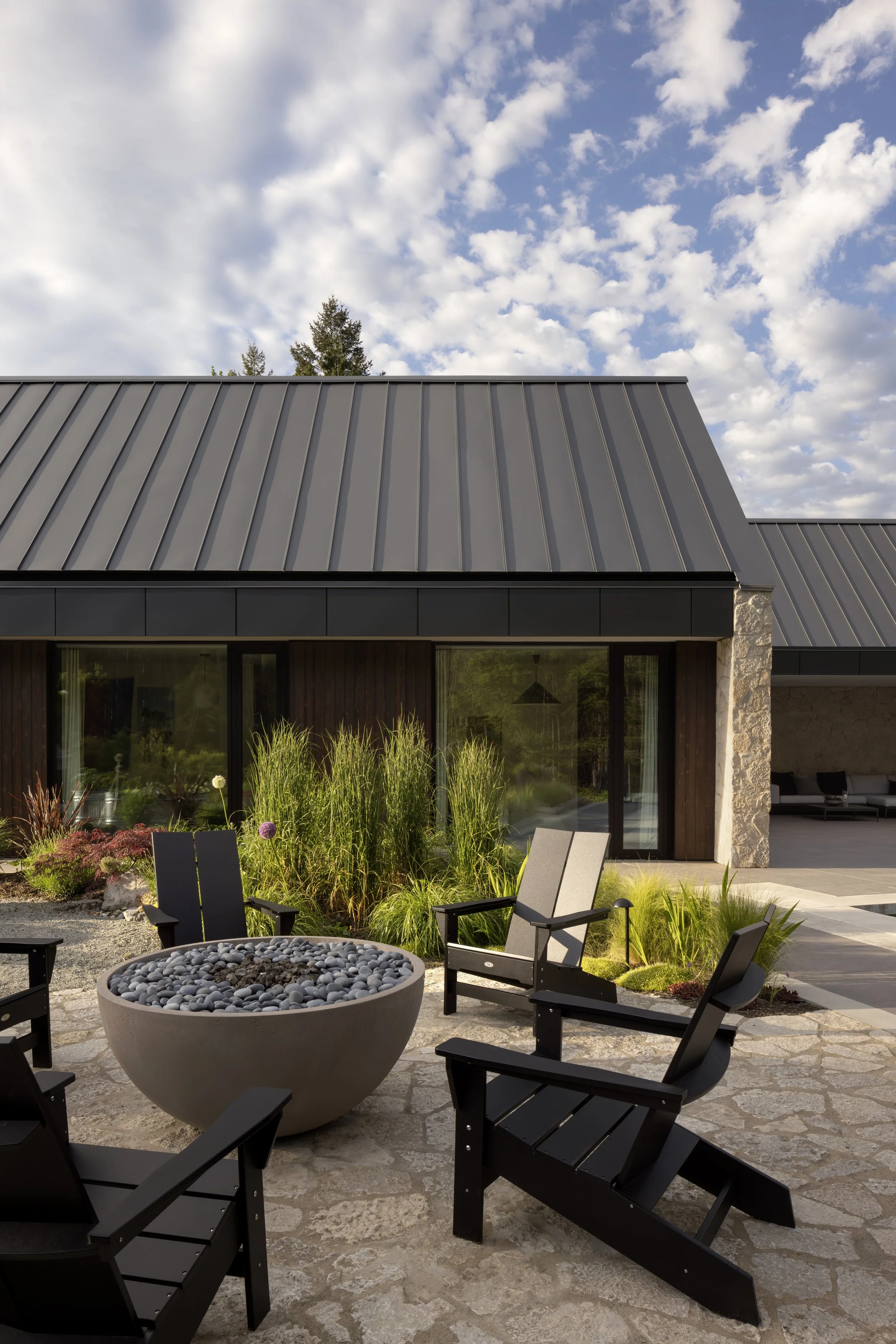  Four distinct outdoor rooms, a bocce court, swimming pool, flower and vegetable garden, and pickleball court, anchor the home and create a seamless relationship between architecture and nature.  