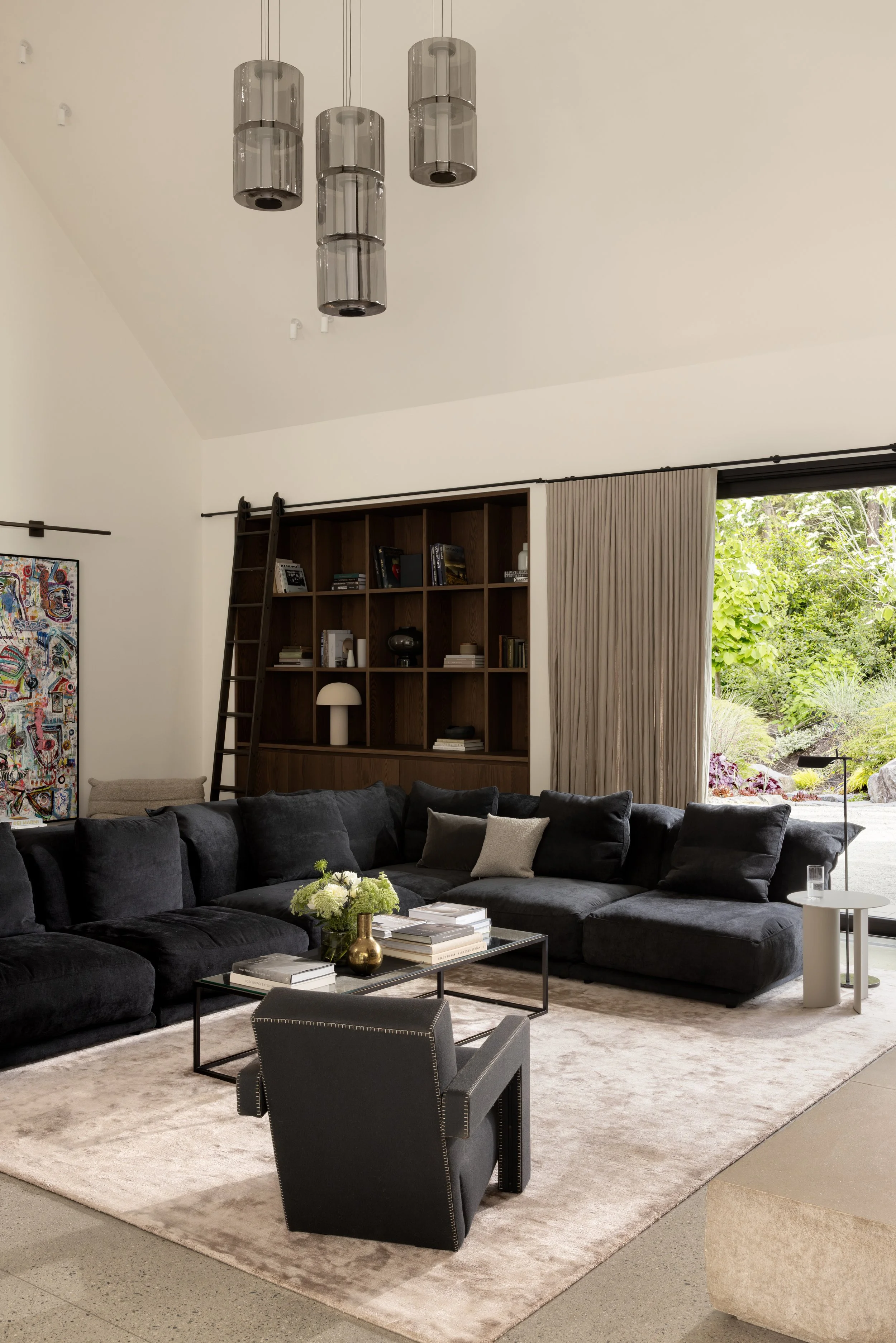  The living room is the defining space of the home: a generous, open volume centred around a dramatic double-sided fireplace. As the heart of the house, it reflects the homeowners’ desire for a space that feels both refined and inviting, equally suit