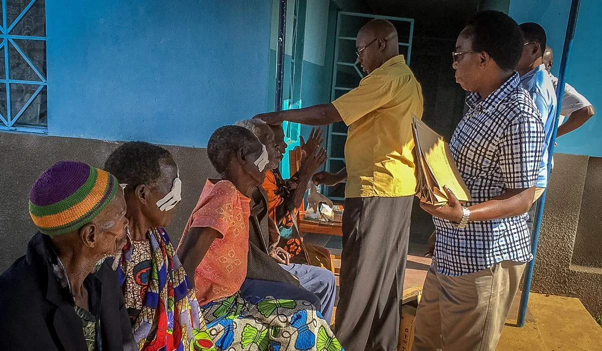 The doctors are removing the bandages. The woman on the end is excited to find her eyesight restored when the bandage was removed.