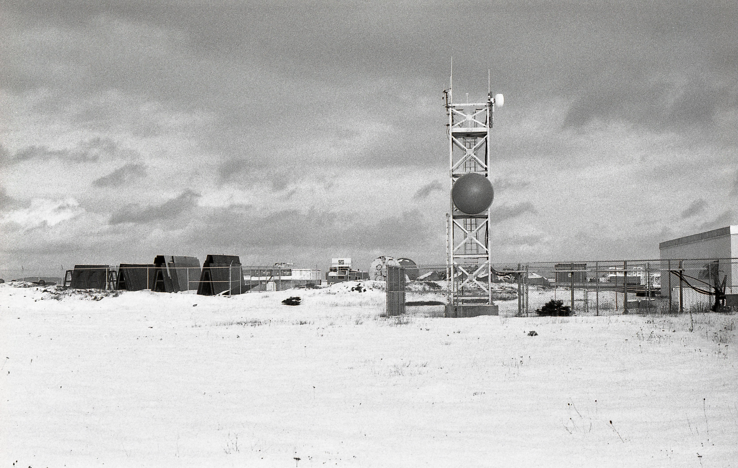 Coast Guard Communications tower at Argentia. There is a constant flow of marine traffic on the bay. Behind the tower is a storage yard of components used in constructing the new nickel processing facility.