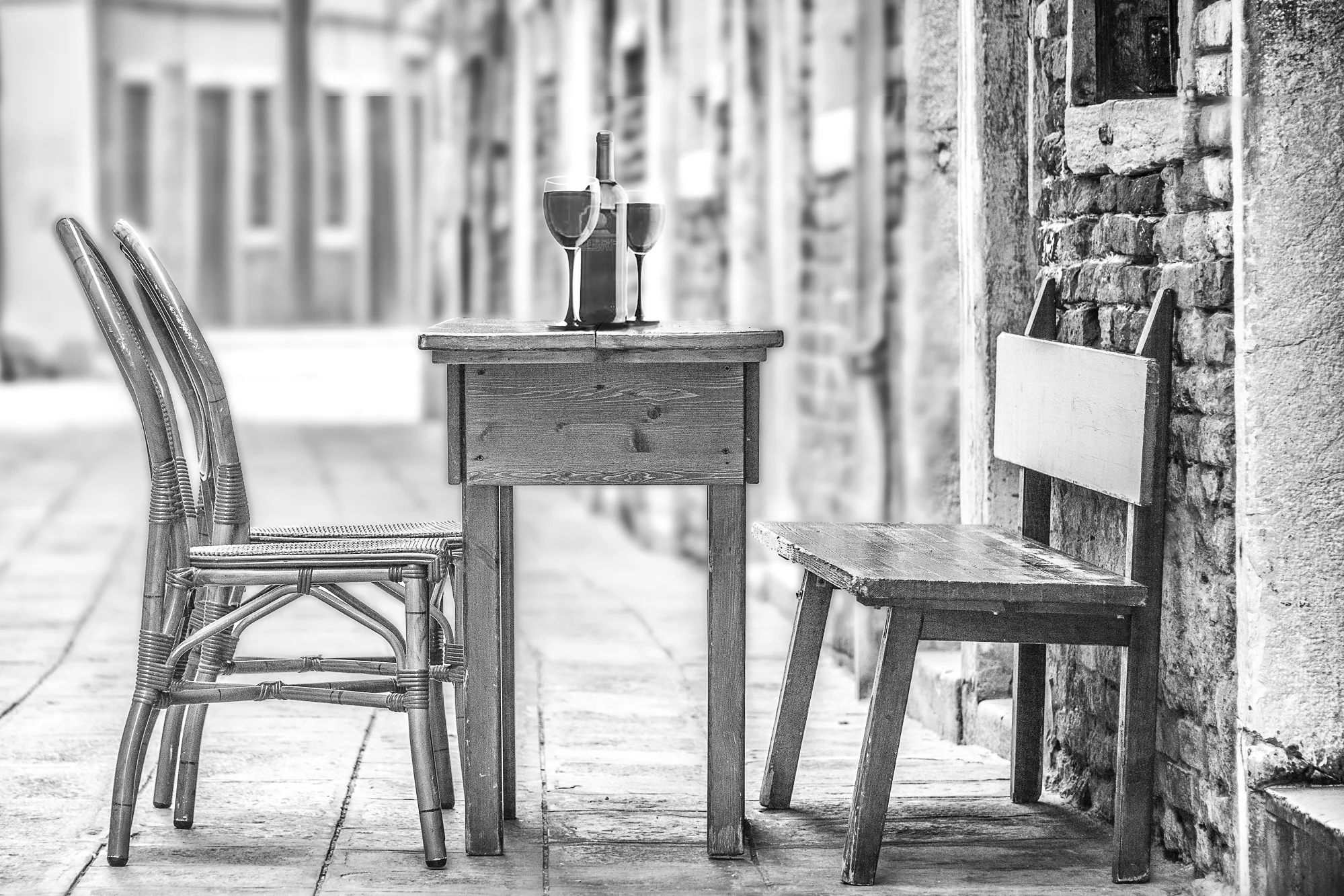 Photo of a trattoria table set with wine glasses and bottle of wine in Venice, Italy
