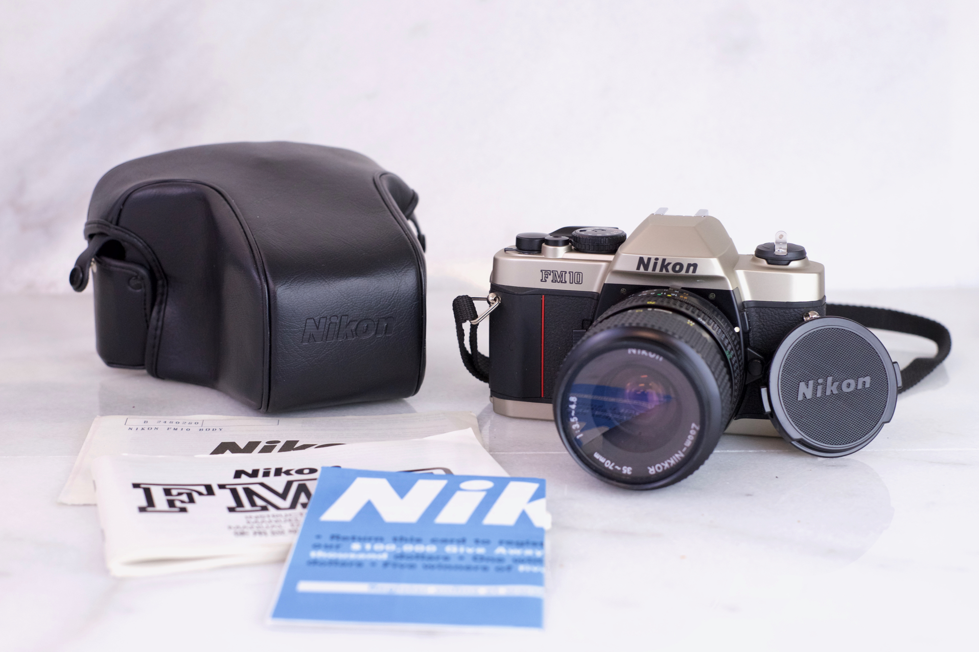 Nikon FM10 35mm Film SLR Camera with Zoom Nikkor 35-70mm F/3.5-4.8 Lens, Strap, Case, Manuals and Batteries - Fully Functional