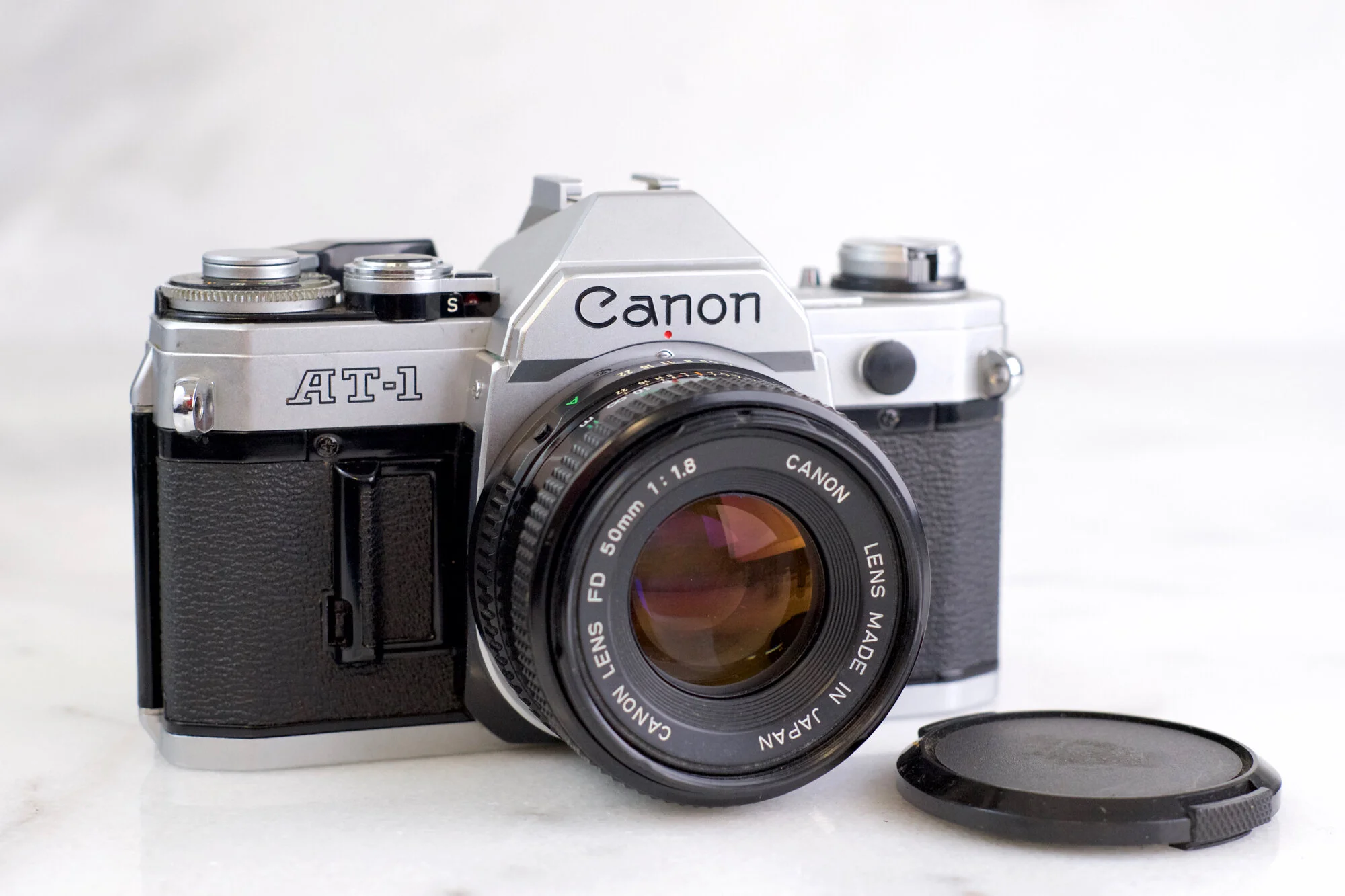 Canon AT-1 35mm Film SLR Camera with Canon FD 50mm F/1.8 Fast Prie Lens, Lens Cap, and Battery - Fully Functional