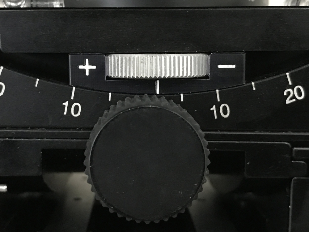 The Cube has two tension adjustment knobs (silver) in both the tilt and the pitch.